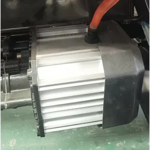 Close-up view of an electric drive motor with a finned aluminum heatsink housing and high-voltage red cable, installed in industrial machinery.