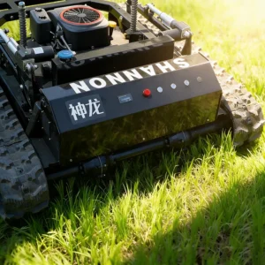 Front side view of a black "Shenlong SHANNON" remote-controlled tracked lawn mower, with control panel and rugged tracks, on a sunlit grass field.