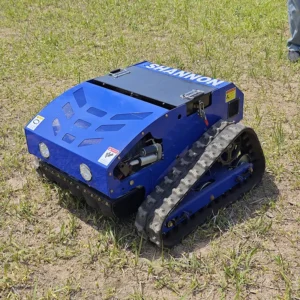 Front side view of a blue "SHANNON" remote-controlled tracked lawn mower with LED headlights and hydraulic components, operating on a grassy field.