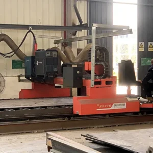 Side view of a red CNC plasma cutting machine with dust extraction hoses, operating in a factory workshop.
