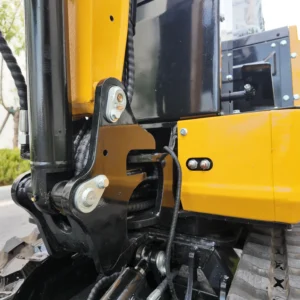 Close-up of a yellow and black mini excavator body connection, showing chrome bolts and protective sleeves.