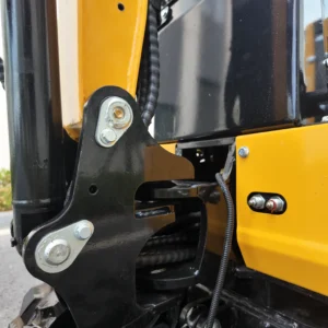 Close-up of a heavy-duty black metal hinge with chrome bolts on a yellow mini excavator.