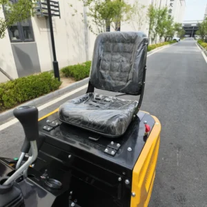 An ergonomic black operator seat on a yellow mini excavator.