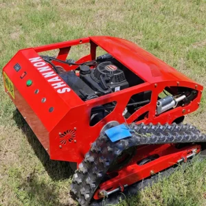 Side front view of a red SHANNON tracked lawn mower with its engine compartment open, positioned on a grass field.