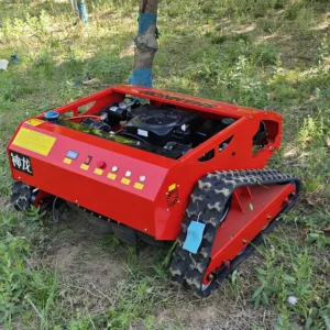 Front side view of a red "Shenlong SHANNON" remote-controlled tracked lawn mower, with exposed gasoline engine and rugged tracks, operating in a grassy woodland area.