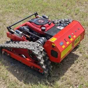 Side front view of a red Shenlong tracked lawn mower with exposed gasoline engine, positioned on a grass field.
