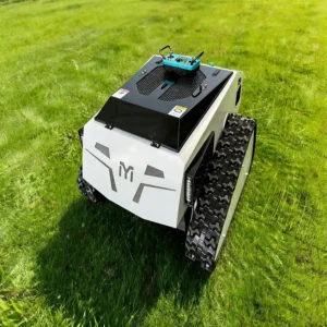 Front side view of a white MYI tracked robot with a remote controller on top, positioned on a lush green grass field.