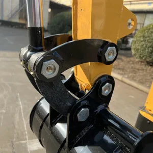 Close-up of mini excavator's boom hinge joint with heavy-duty bolts and hydraulic cylinder connection