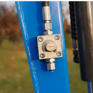 Close-up of mini excavator boom-mounted hydraulic control valve with square body and fittings