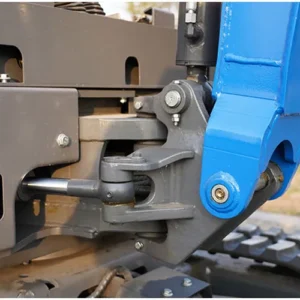 Close-up of mini excavator boom swing joint with heavy-duty bolts and hydraulic linkage