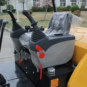 Close-up of mini excavator cabin with dual joystick controls, safety lever and operator seat with protective cover