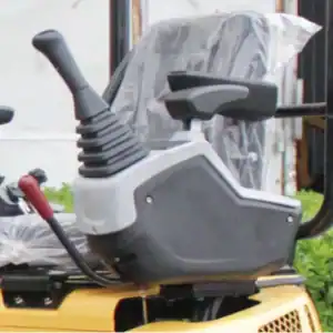 Close-up of mini excavator's cabin joystick control handle with ergonomic design for operator comfort