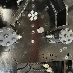 Close-up of mini excavator chassis showing hydraulic motors, bolted connections and black metal base plate