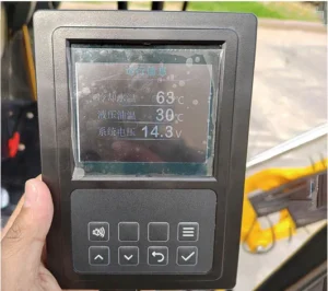 Close-up of mini excavator's digital monitor showing water temperature, hydraulic oil temp and system voltage