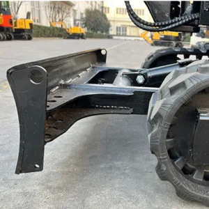 Close-up of mini excavator's dozer blade, hydraulic cylinder and tracked undercarriage in outdoor factory area