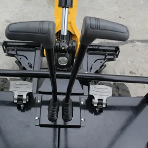 Top view of mini excavator's foot pedals and control levers with black cabin floor and hydraulic arm