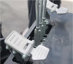 Close-up of mini excavator foot pedal controls for auxiliary functions and travel
