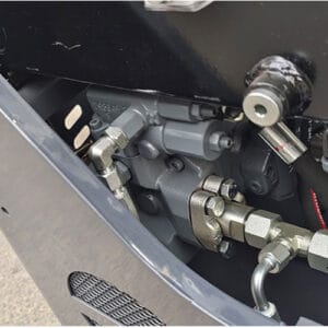 Close-up of mini excavator main hydraulic pump, control valve and metal fittings