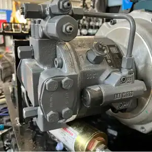 Close-up of mini excavator's hydraulic pump with valves and fittings for construction machinery power system