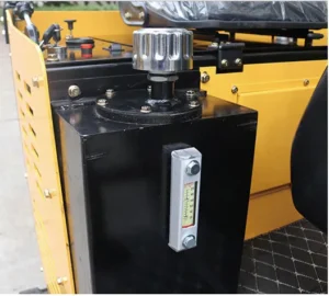 Close-up of black hydraulic tank on yellow mini excavator with level gauge and cap