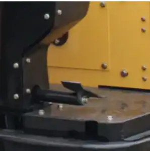 Close-up of mini excavator's locking latch mechanism with bolts and metal structure for construction equipment