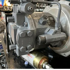 Close-up of mini excavator main hydraulic pump with valves, fittings and QR code label