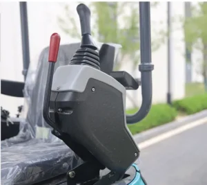 Close-up of mini excavator operator joystick with red safety lever and ergonomic design