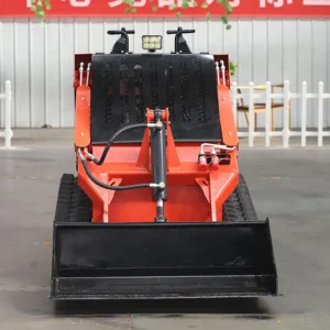 Front view of orange walk-behind tracked skid steer loader with level bucket, joystick controls and work light