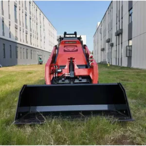 Front view of red ride-on tracked skid steer loader with level bucket, hydraulic fittings and rugged rubber tracks