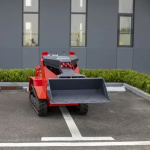 Front view of red ride-on tracked skid steer loader with level bucket, hydraulic fittings and rugged tracks