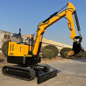 Side view of yellow mini crawler excavator with extended bucket, dozer blade and open operator station in factory yard