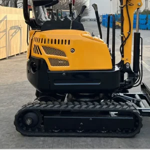Side view of yellow mini crawler excavator with tracked undercarriage, cabin and hydraulic arm in factory yard