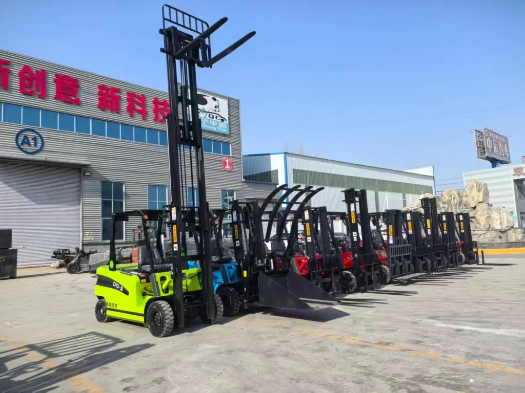 Complete lineup of multi-color electric counterbalance forklifts fitted with forks, buckets, and clamp attachments displayed outside manufacturing plant