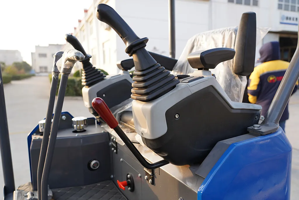 Close-up view of ergonomic hydraulic joystick control console inside a compact mini excavator, featuring dual operating levers and safety handles